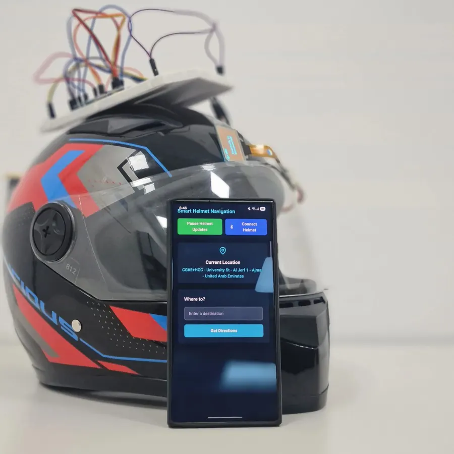 Motorcycle helmet with an ESP32 breadboard on top and a phone showing the navigation app